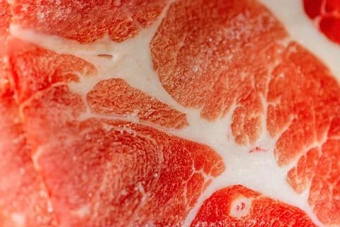The delicate marbled texture of bright red frozen pork slices Stock Photos