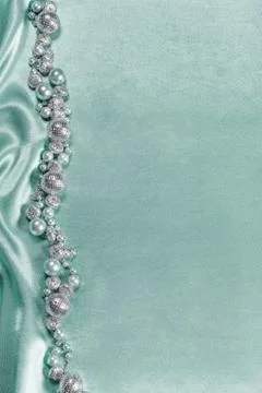 Delicate satin background with beads Stock Photos