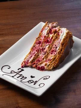 Delicate slice of layered cake sits on a white plate Stock Photos