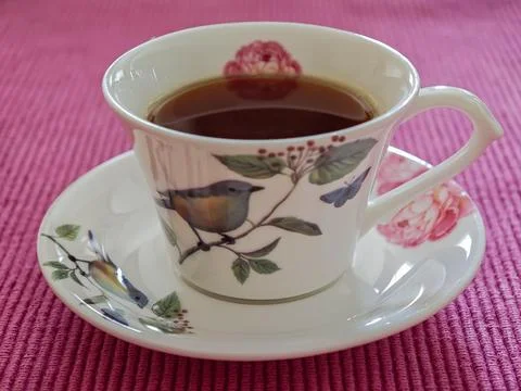Delicate teacup with bird design Stock Photos