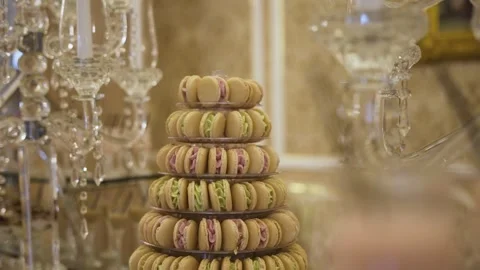 A delicate tower of pastel-colored macarons on a dessert stand, with a backdrop  Stock Footage 262629698