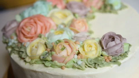 Delicate white wedding cake with a wreath of edible roses in pastel colors. Stock Footage 143744154