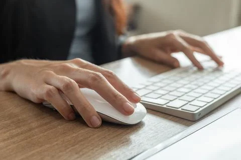 Delicate woman's hands working on a mouse a computer keyboard Stock Photos