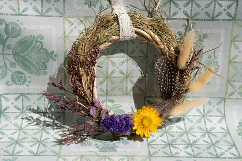 Delicate wreath features an array of dried flowers, herbs, and grasses, showc Stock Photos
