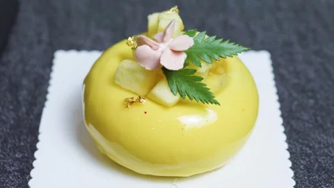 Delicate yellow mango apple mousse cake garnished with pineapple chunks, gold Stock Footage 314892199