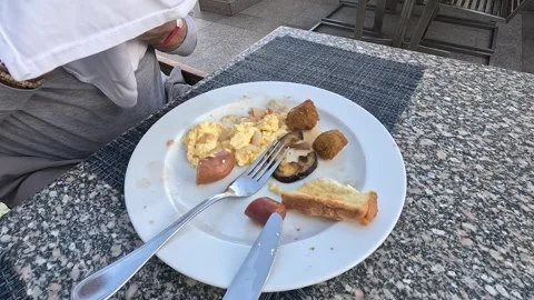 A Delicately Savoring Breakfast Scene Featuring Scrambled Eggs, Sausages, and 库存影片 331079023