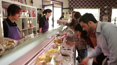 Delicatessen customers shopping.  A relaxed cafe shop where people are buying Stock Footage