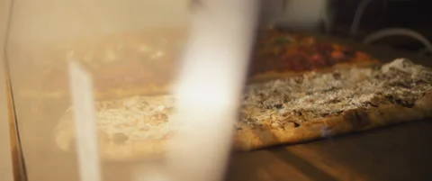 Delicious al taglio pizzas with different toppings placed on a wooden surface Stock Footage 147518947