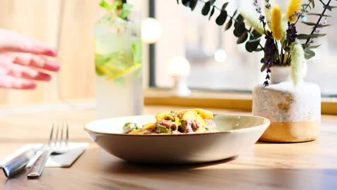 A delicious and delicious dish served with a refreshing drink in a cozy Stock Footage 311872015