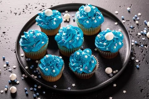 Delicious and homemade cupcakes with sprinkles and blue cream. Stock Photos