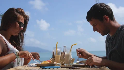 Delicious and nutritious breakfast of a young couple in a cafe on vacation Stock Footage 92404609