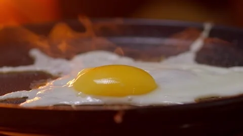 A Delicious and Sizzling Fried Egg Cooking in a Pan with Steam Rising Stock Footage 306015736