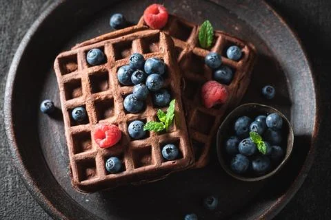 Delicious and sweet dark waffles with fresh berries. Stock Photos