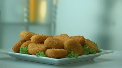 Delicious appetizing chicken nuggets breaded fall in a plate Stock Footage 116875825