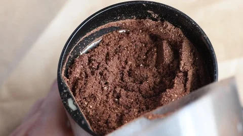 Delicious aromatic roasted cocoa beans are ground in a coffee grinder at home Stock Footage 94251766