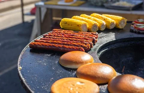 Delicious array of sausages sizzling on a flat top grill. The sausages are ar Stock Photos