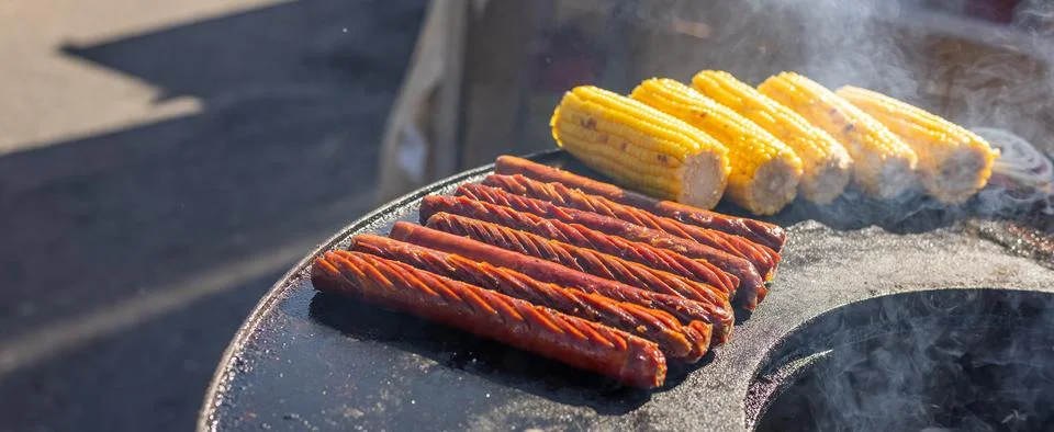 Delicious array of sausages sizzling on a flat top grill. The sausages are .. Stock Photos