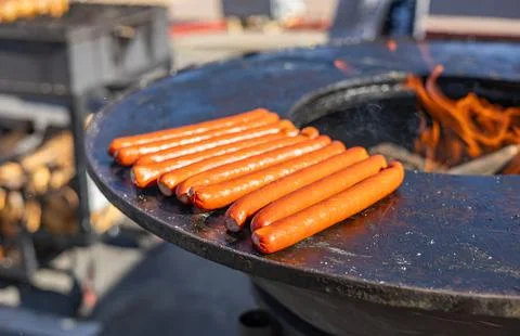 Delicious array of sausages sizzling on a flat top grill. The sausages are ar Stock Photos