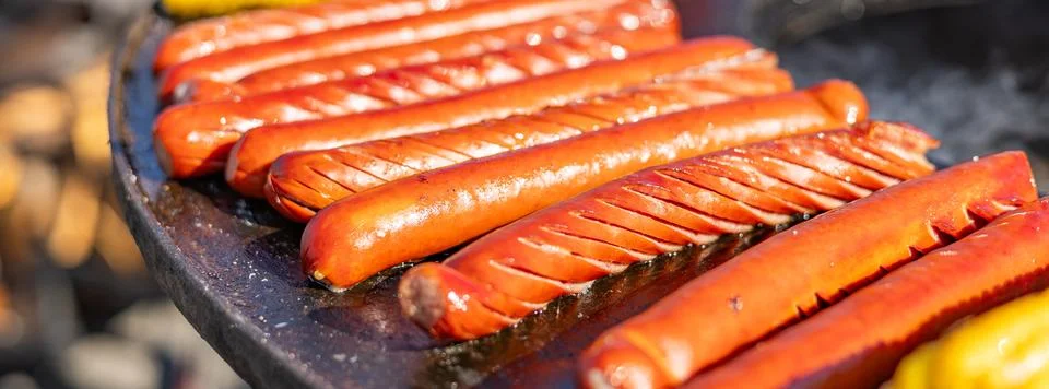 Delicious array of sausages sizzling on a flat top grill. The sausages are .. Stock Photos