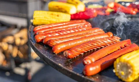 Delicious array of sausages sizzling on a flat top grill. The sausages are .. Stock Photos