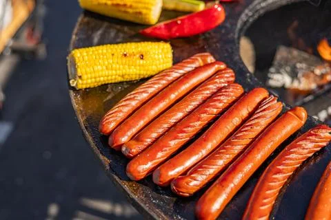 Delicious array of sausages sizzling on a flat top grill. The sausages are .. Stock Photos