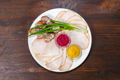 Delicious assorted cold cuts with dipping sauces and green onions Stock Photos