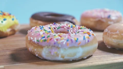 Delicious Assorted Donuts on Wooden Table 4K Stock Footage 125412045
