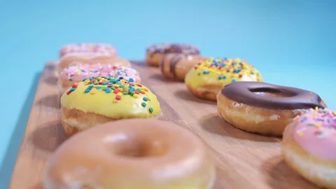 Delicious Assorted Donuts on Wooden Table 4K Video stock 125456410
