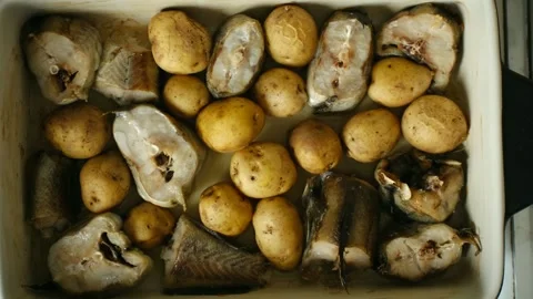Delicious baked fish with roasted potatoes in a casserole dish Stock Footage 337902139