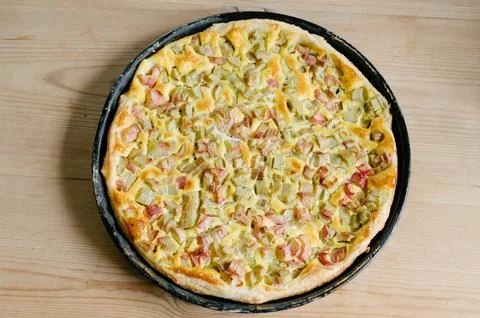 Delicious baked pie on flat baking pan placed on wooden surface in daylight Stock Photos