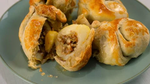 Delicious baked wrapped in dough pears with nuts filling on plate on kitchen. Video stock 313047701