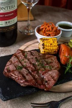 Delicious beef steak grill with corn and tomato in a nice table Stock Photos
