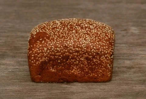 Delicious black bread on old tree background Stock Photos