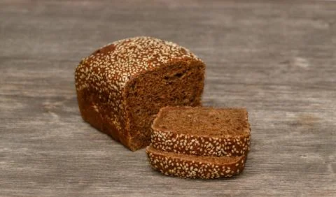 Delicious black bread on old tree background Stock Photos