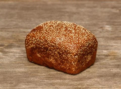 Delicious black bread on old tree background Stock Photos