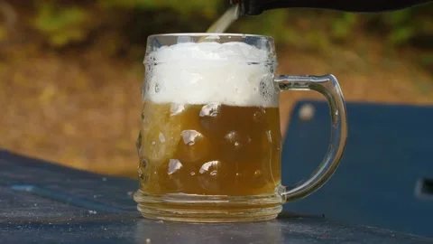 Delicious bottle of beer flows into a classic German beer glass 스톡 동영상 163470600