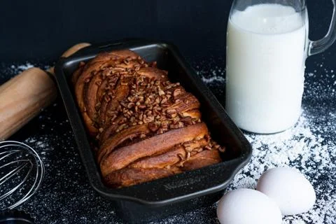 Delicious braid bread garnished with ground nuts with a bottle of milk, eggs Stock Photos