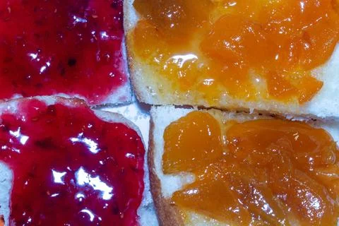 Delicious breakfast assortment with raspberry jam and apricot preserve Stock Photos
