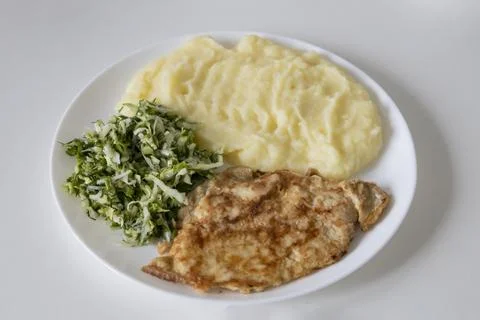 A delicious breakfast or lunch with mashed potatoes, chop with salad - gree.. Stock Photos