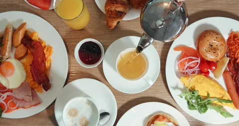 Delicious breakfast spread on table with pastries, coffee, juice, eggs Stock Footage 318120695