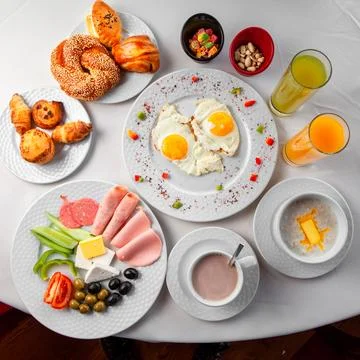 Delicious breakfast in a table with salad, fried eggs and pastry top view o.. Stock Photos
