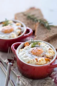 A delicious breakfast time, one serving of red pots of eggs Foto stock