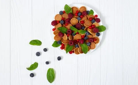 Delicious breakfast with tiny mini pancakes, blueberry, raspberry, red curran Stock Photos