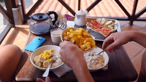 Delicious breakfast on vacation, impose mango and banana in oatmeal. HD Stock Footage 90841906