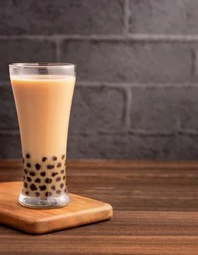 Delicious bubble milk tea with tapioca pearl ball in glass on wooden table an Stock Photos