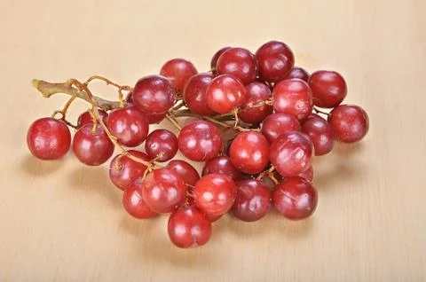 Delicious bunch red seedless crimson grape on wood plank Foto stock
