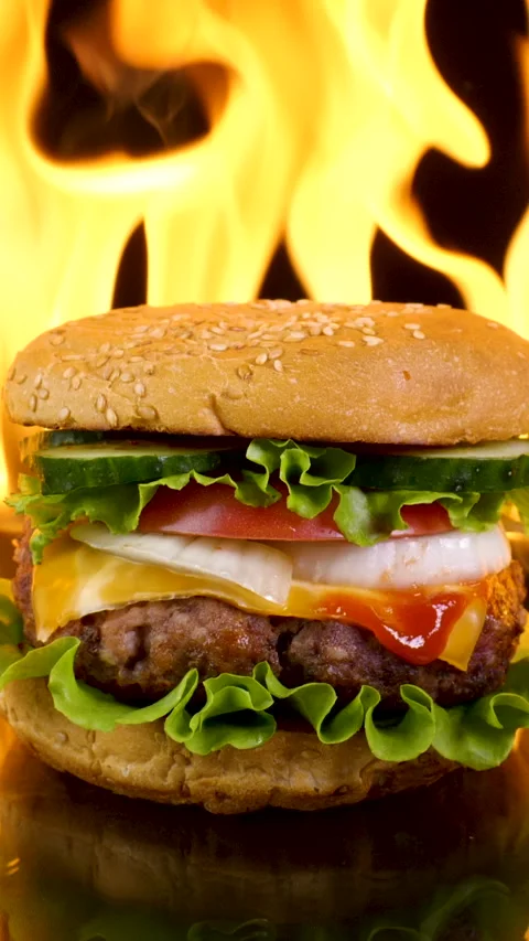 Delicious burger on the background of fire Stock Footage 258595700