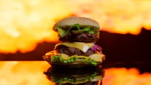 Delicious burger on the black mirror surface. The flame of grill on the Stock-Footage 92513981