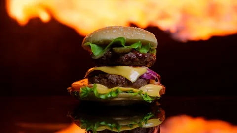 Delicious burger is on fire on the black mirror surface Stock Footage 92514632