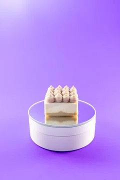 Delicious cake placed on a round stand against a purple background in a sim.. Stock Photos
